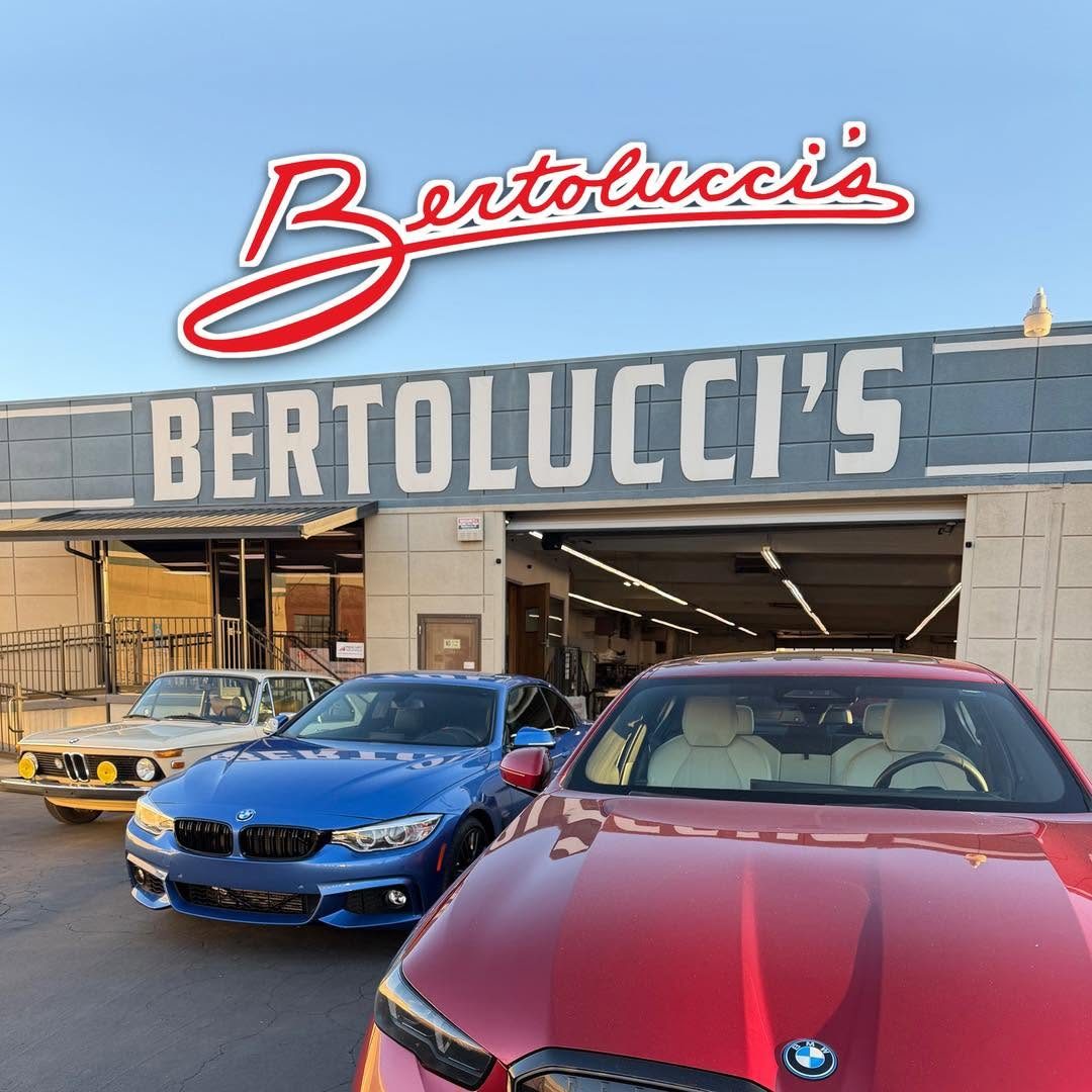 The Bertolucci's building on Stockton Blvd. with its large white lettered sign and open service bay, and a classic BMW, a blue BMW and a red BMW parked in front