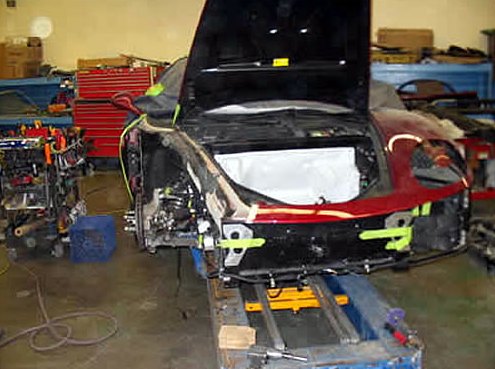 Step 6: Ferrari front end on the frame bench with the hood raised and the rebuilt front structure exposed